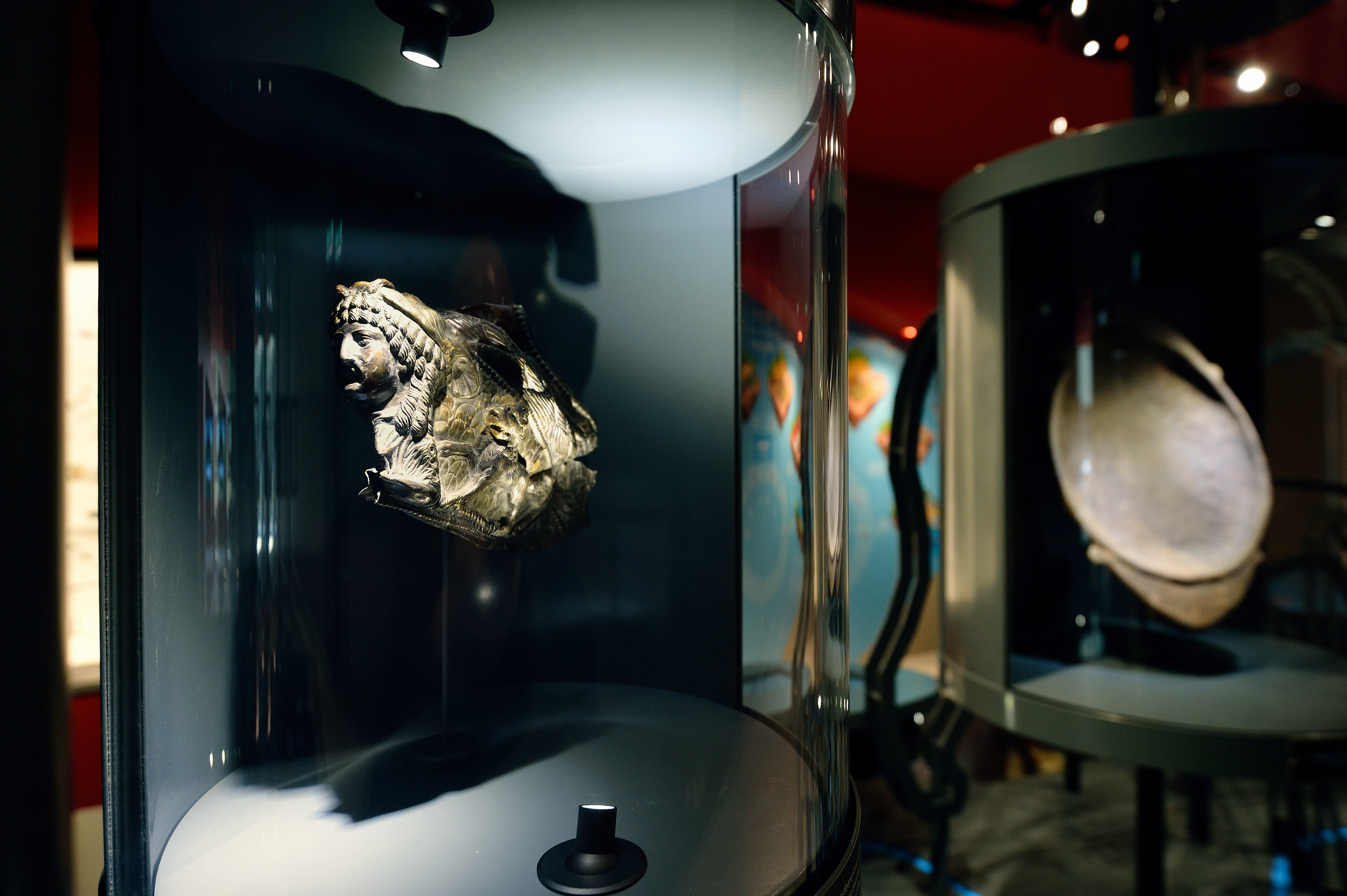 Detail van antieke beeldhouwwerken achter glazen vitrines in museum Castellum Hoge Woerd.